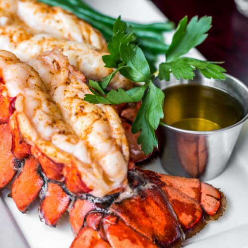 Split Maine lobster tail on a plate with butter